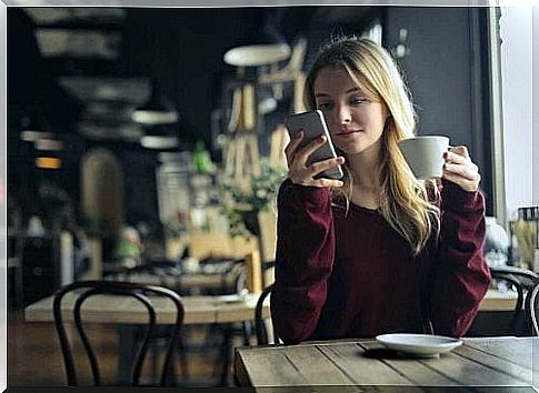 Woman checking her mobile phone at the cafe