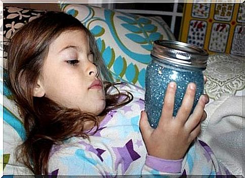 Girl relaxes in bed with sensory bottle