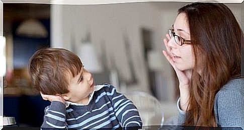 Mother with glasses talks to child in striped shirt