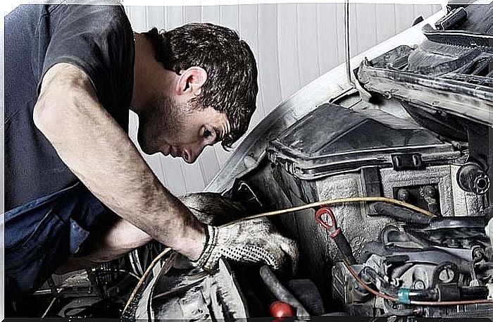 A mechanic looking at a car engine